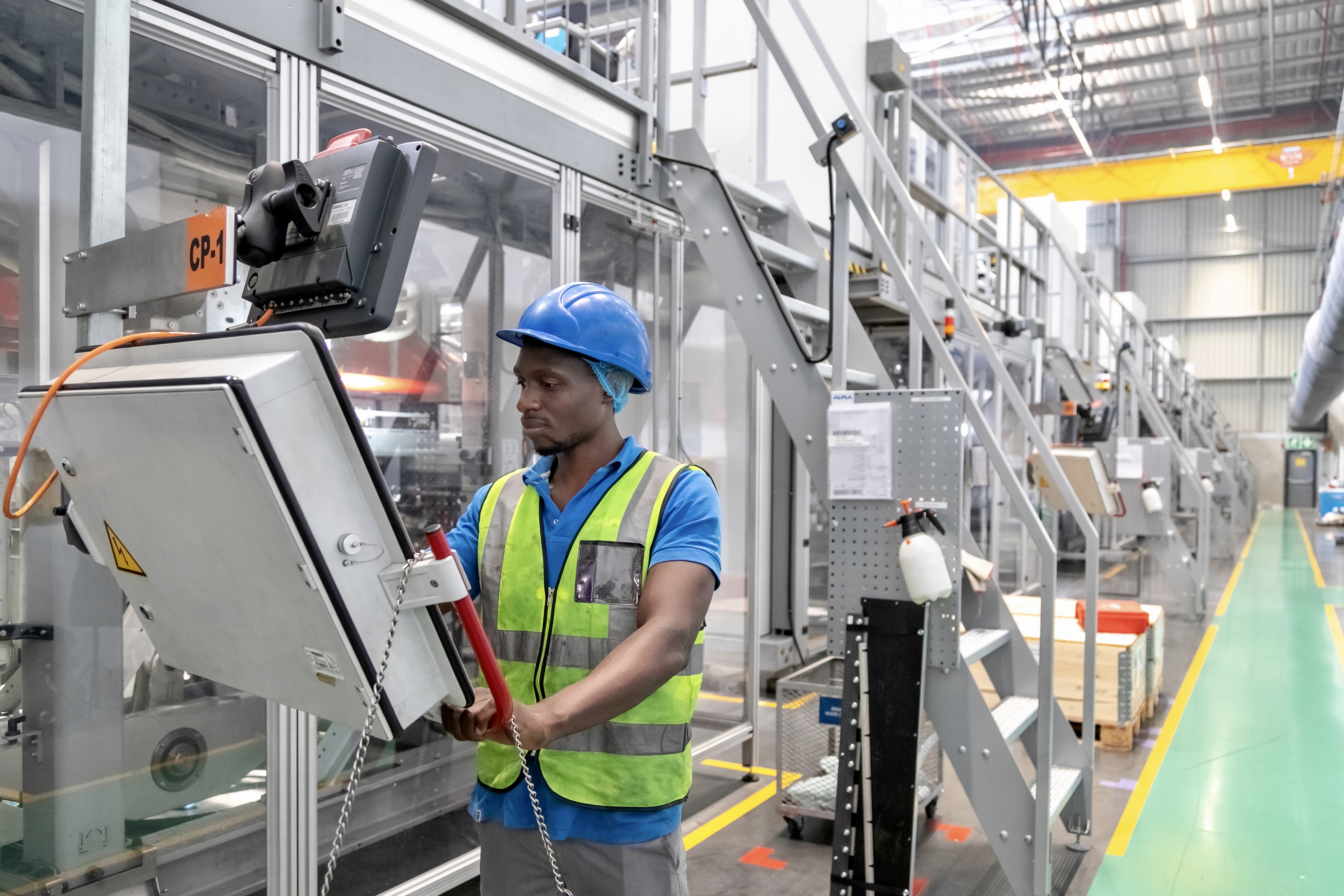 LPLA employee operating machinery in the Lanseria production facility, demonstrating advanced manufacturing technology and safety measures.