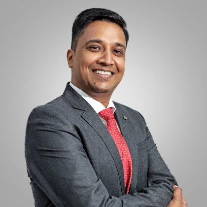 Anshul Goel, Cluster Procurement Director at ALPLA, wearing a dark gray suit with a red tie, smiling confidently against a neutral background.